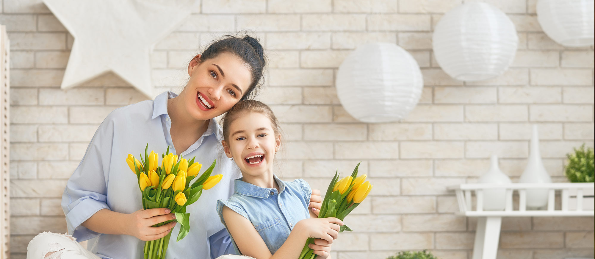 Mother and daughter holding yellow tulips